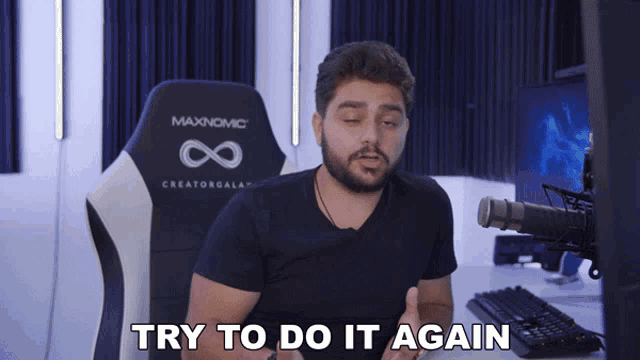 a man is sitting in a maxnomic chair and saying try to do it again