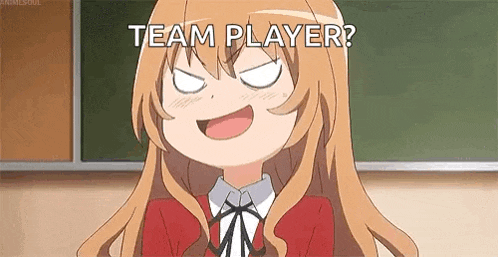 a girl is making a funny face in front of a blackboard and says `` team player '' .