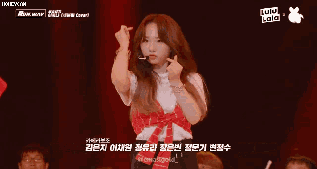 a girl is making a heart shape with her hands and the words lulu lala are on the bottom of the screen