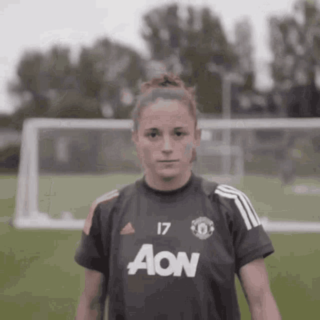 a female soccer player wearing a black aon jersey