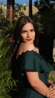 a woman wearing a green off the shoulder dress