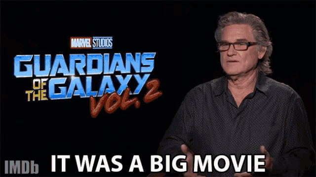 a man talking in front of a guardians of the galaxy vol 2 sign