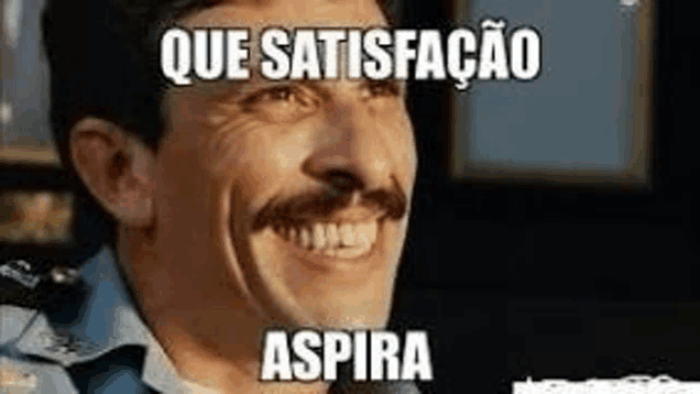 a man with a mustache is smiling in front of a microphone with a meme .