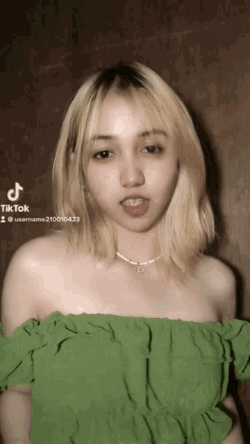 a woman in a green off the shoulder top has a tiktok account