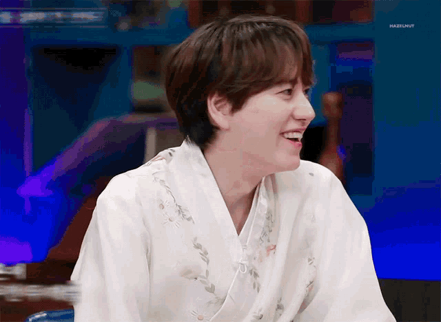 a young man wearing a white kimono is smiling with hazelnut written on the bottom