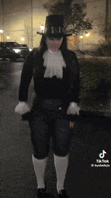 a woman wearing a top hat and white socks is standing on a street