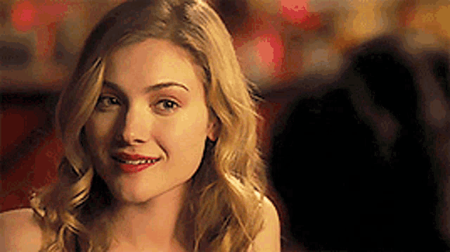 a close up of a woman 's face with blonde hair and red lips .