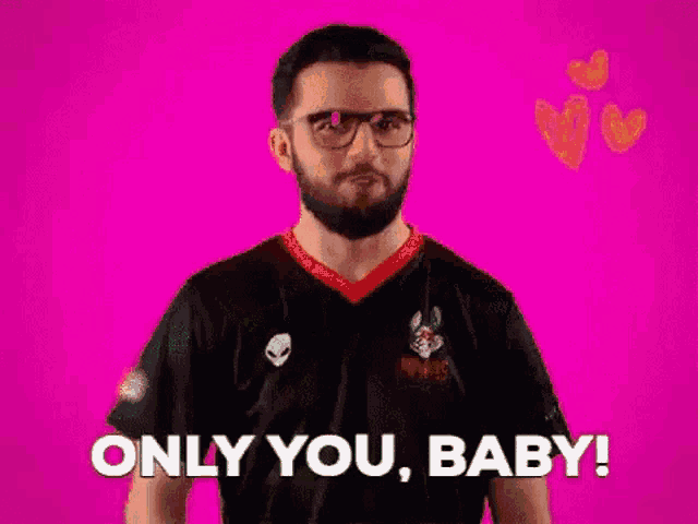 a man with a beard and glasses is standing in front of a pink background .