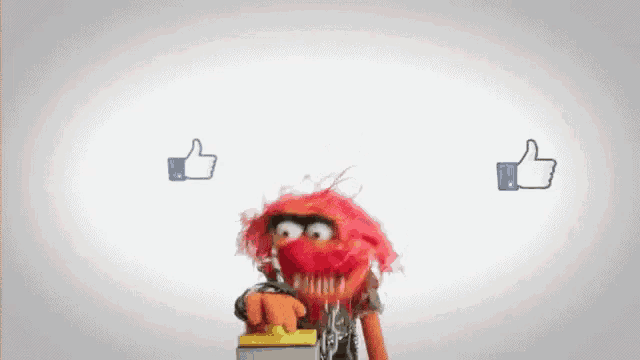 a muppet with red hair is pressing a button with two thumbs up behind it
