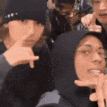 a group of people are posing for a picture together and one of them is wearing a hooded jacket .