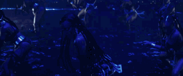 a group of women are dancing in a dark pool of water