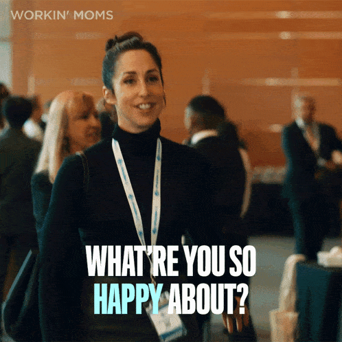 a woman with a lanyard around her neck is smiling and says " what 're you so happy about "