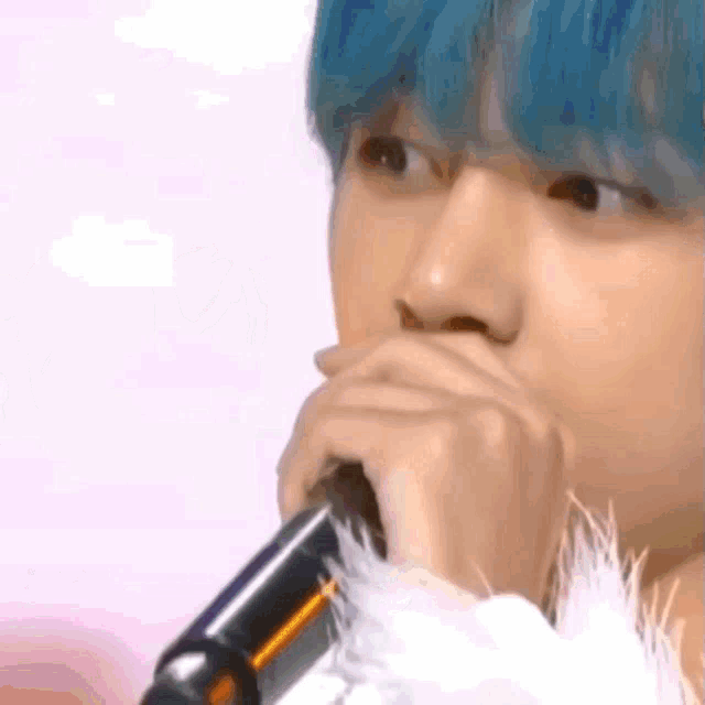 a close up of a person holding a microphone in their hand .