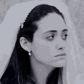 a close up of a woman wearing a veil and earrings .