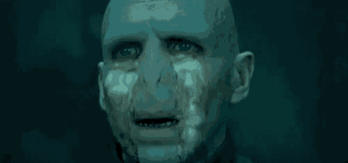a close up of a bald man 's face with tears coming out of it .