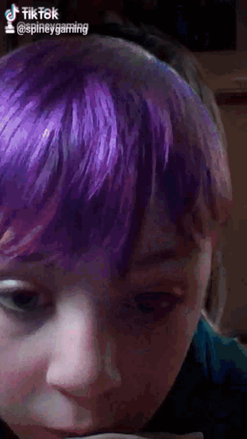 a close up of a person 's face with purple hair and the words tiktok @spineygaming