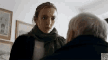 a woman in a green scarf is talking to an older man