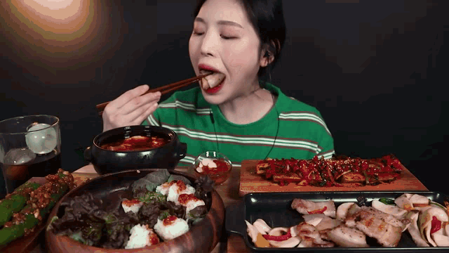 a woman is eating a meal with chopsticks and a bowl of soup