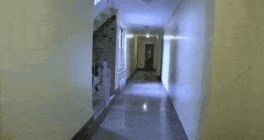 a woman walking down a hallway talking on her phone