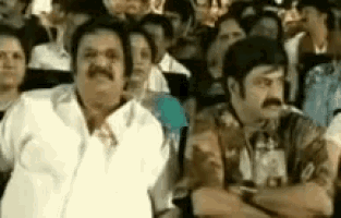 a group of people are sitting in a theatre watching a movie .