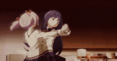 a couple of anime girls are dancing together in a dark room