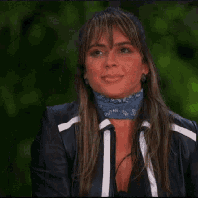 a woman wearing a black jacket and a blue scarf around her neck with the word duan on it