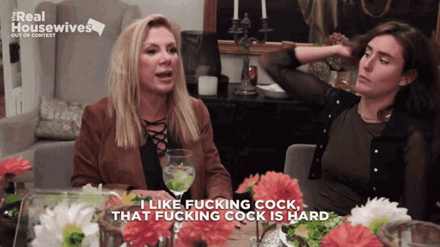 two women are sitting at a table and one of them says " i like fucking cock "