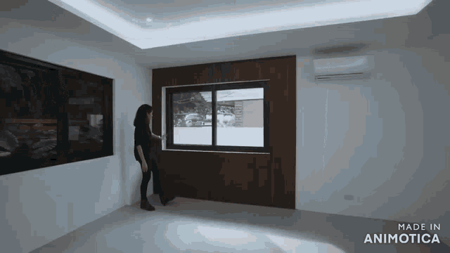 a woman standing in front of a window with the words made in animatica on the bottom right