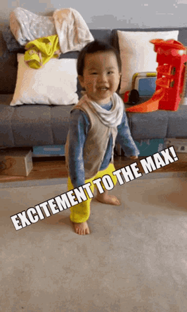 a little boy standing in front of a couch with the words excitement to the max on the floor