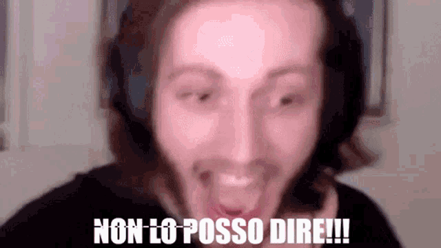 a man wearing headphones is making a funny face with the words non lo posso dire written above him .