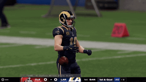 a football player in a rams uniform stands on the field