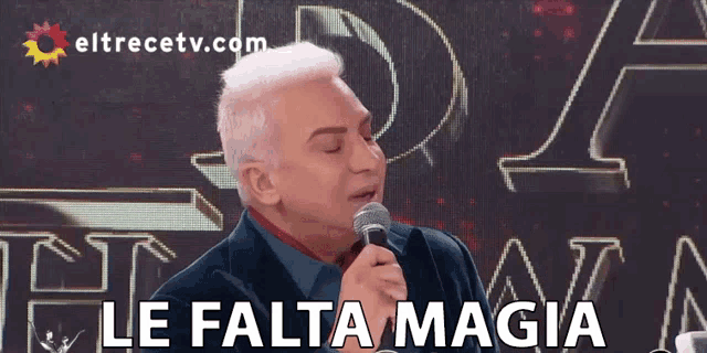 a man singing into a microphone with the words le falta magia written below him
