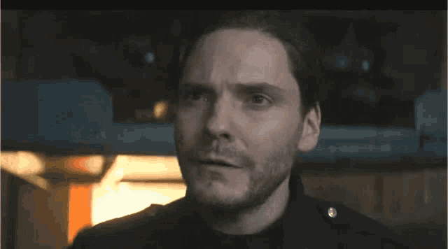 a close up of a man 's face with a beard looking at the camera .