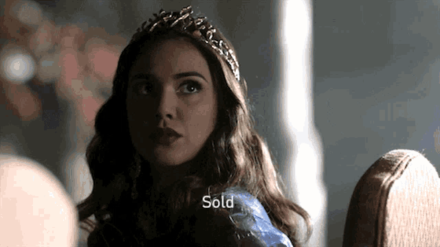 a woman wearing a blue dress and a tiara has the word sold below her