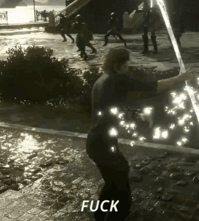 a man is holding a sword in a video game and the word fuck is on the bottom of the screen .