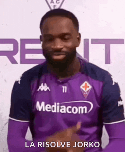 a man wearing a purple jersey with the word mediacom on it is giving a thumbs up .