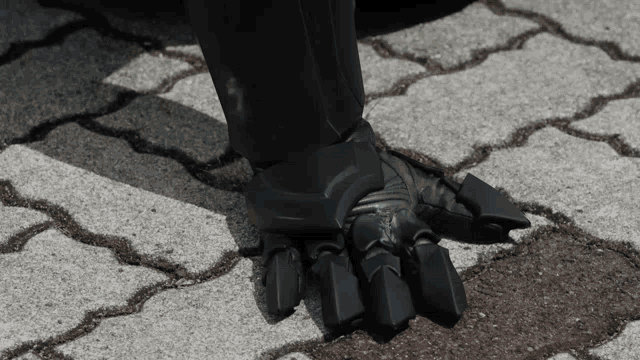 a close up of a person 's foot on a brick pavement