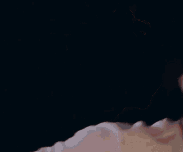 a close up of a man 's face with his eyes closed and his mouth open .