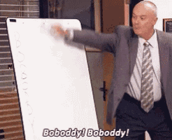 a man in a suit and tie is pointing at a white board and says bobody