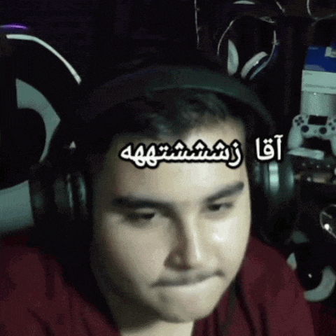 a man wearing headphones and a red shirt has arabic writing on his forehead