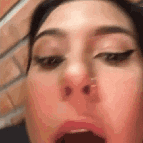 a close up of a woman 's face with her mouth wide open .