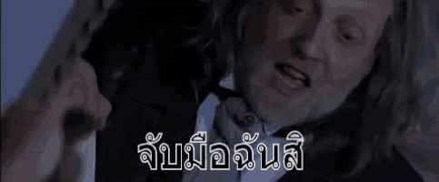 a man in a suit and tie is talking to a woman in a dark room .