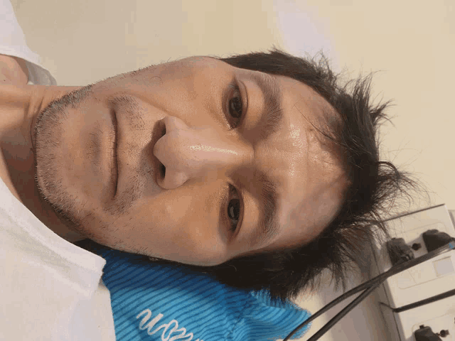 a man with a beard is laying on a blue striped pillow that says ' n82m ' on it