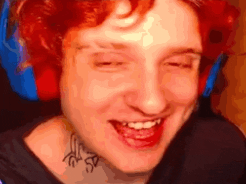 a close up of a person 's face with red hair and headphones on