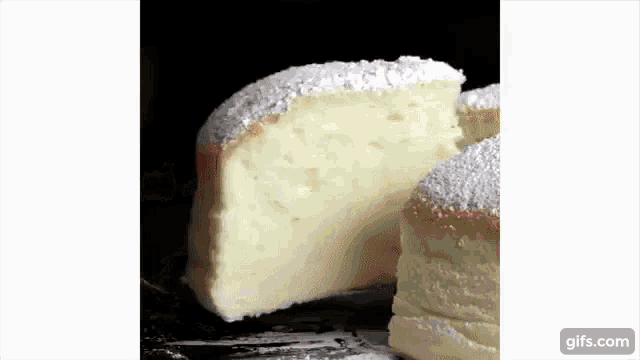 a slice of cheesecake with powdered sugar on top is on a plate .