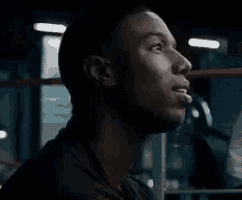 a man is smiling in a dark room in a gym .