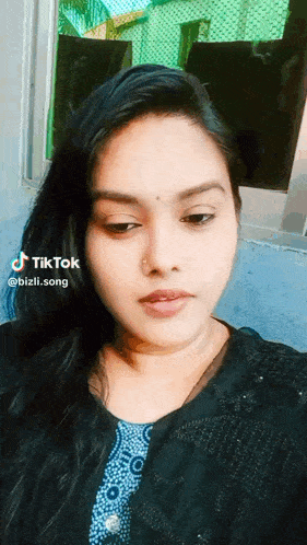 a woman 's face is shown in a tiktok video taken by bizlii.song