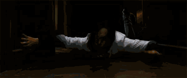 a person is laying on the floor with their arms outstretched in a dark room .