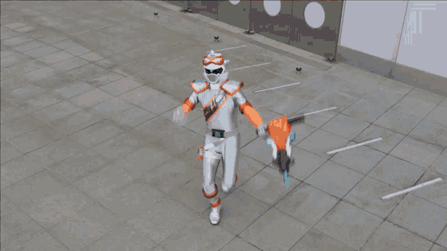 a man in a silver and orange costume is holding a gun