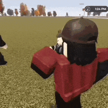 a person in a red shirt and black hat is standing in a field holding a gun .